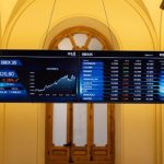 Pantallas digitales en el Palacio de la Bolsa de Madrid mostrando la cotización del Ibex 35 en 17.820,80 puntos con tendencia a la baja durante la sesión de mayo de 2026.