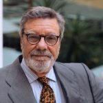Retrato en plano medio de un directivo del Club de Exportadores e Inversores Españoles vistiendo traje gris y corbata estampada, representando la postura del sector exterior en 2026.