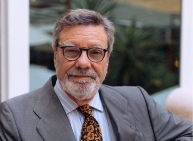 Retrato en plano medio de un directivo del Club de Exportadores e Inversores Españoles vistiendo traje gris y corbata estampada, representando la postura del sector exterior en 2026.